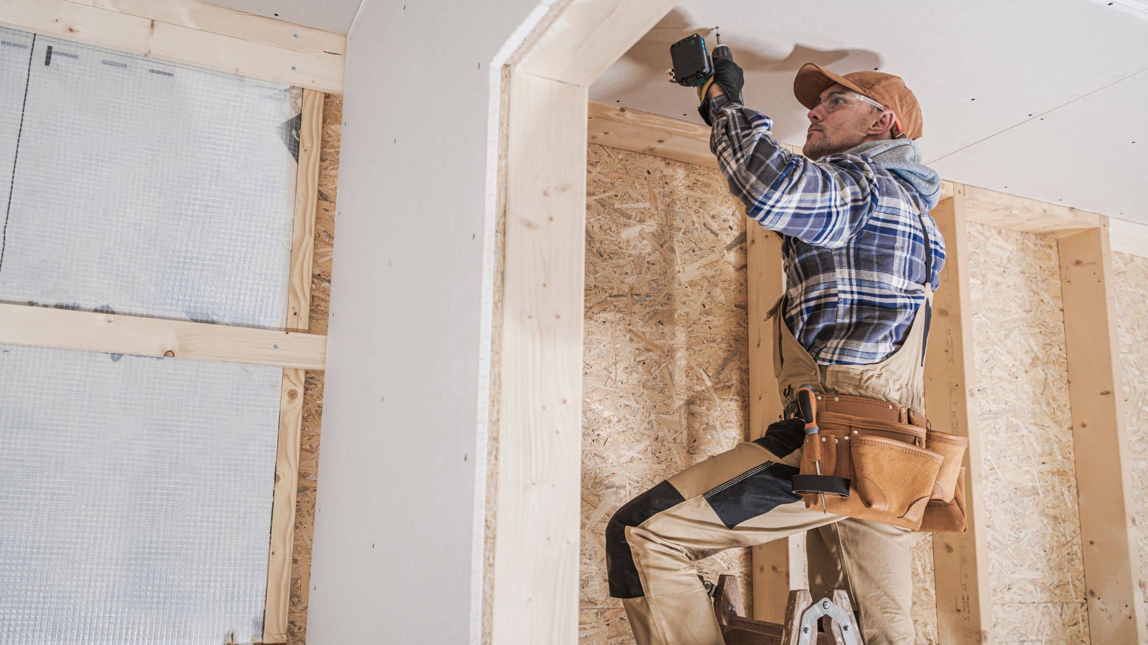 Construction worker installing drywall during a remodeling project.